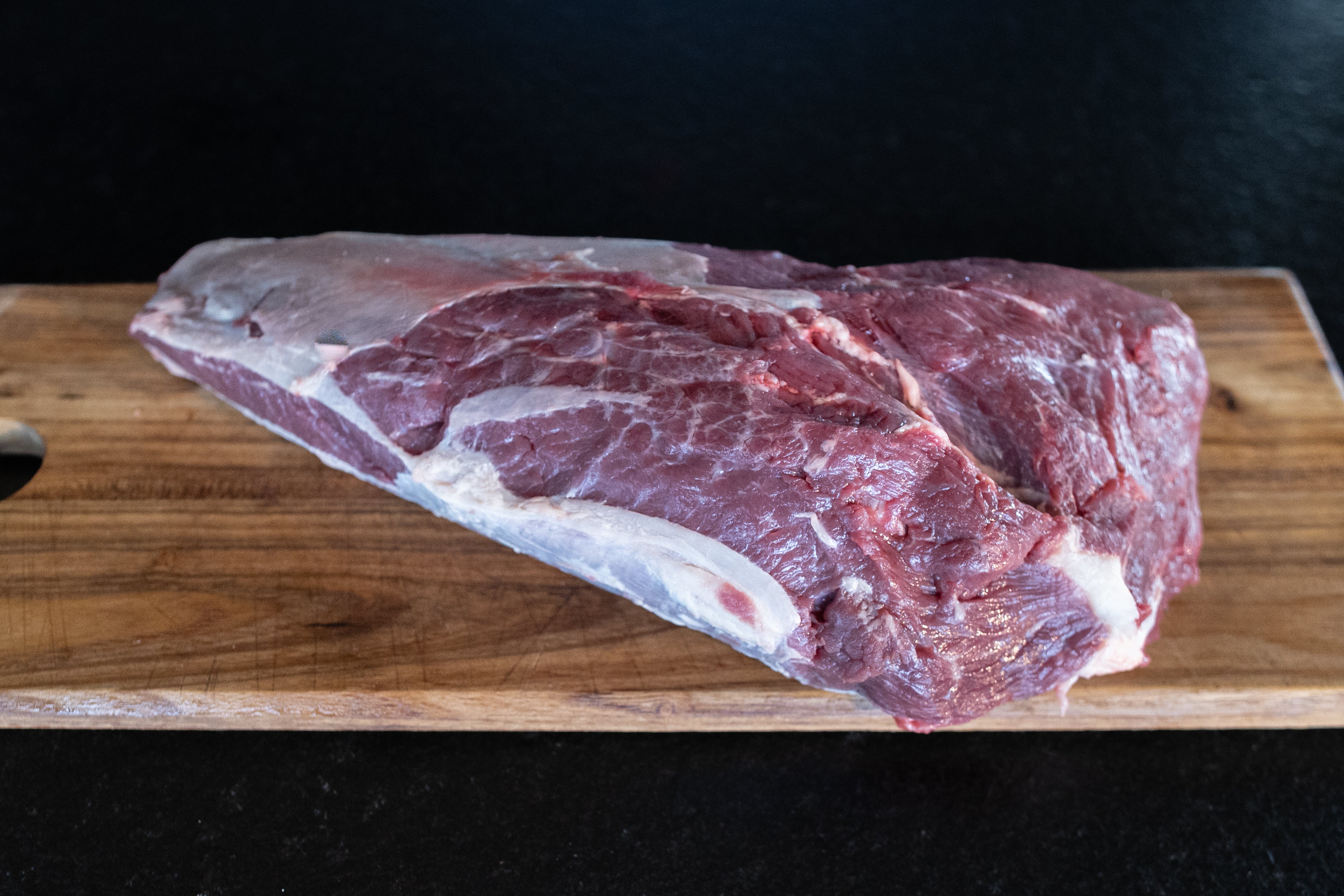 Hovězí váleček z plece Fox Meadows na dřevěném prkénku – připravený k pečení a dušení