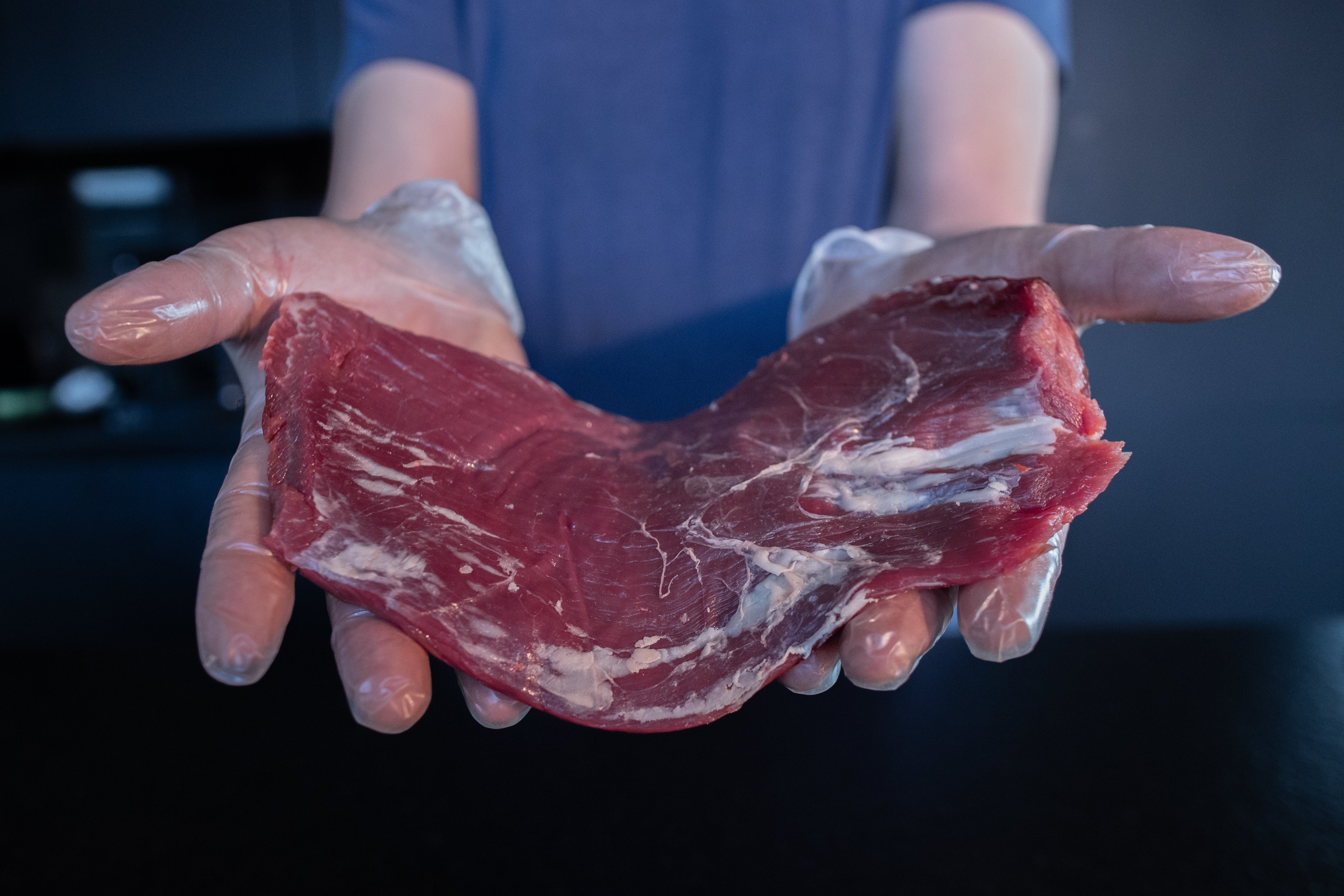 Řezník drží hovězí flank steak Fox Meadows – kvalitní maso pro dokonalé steaky