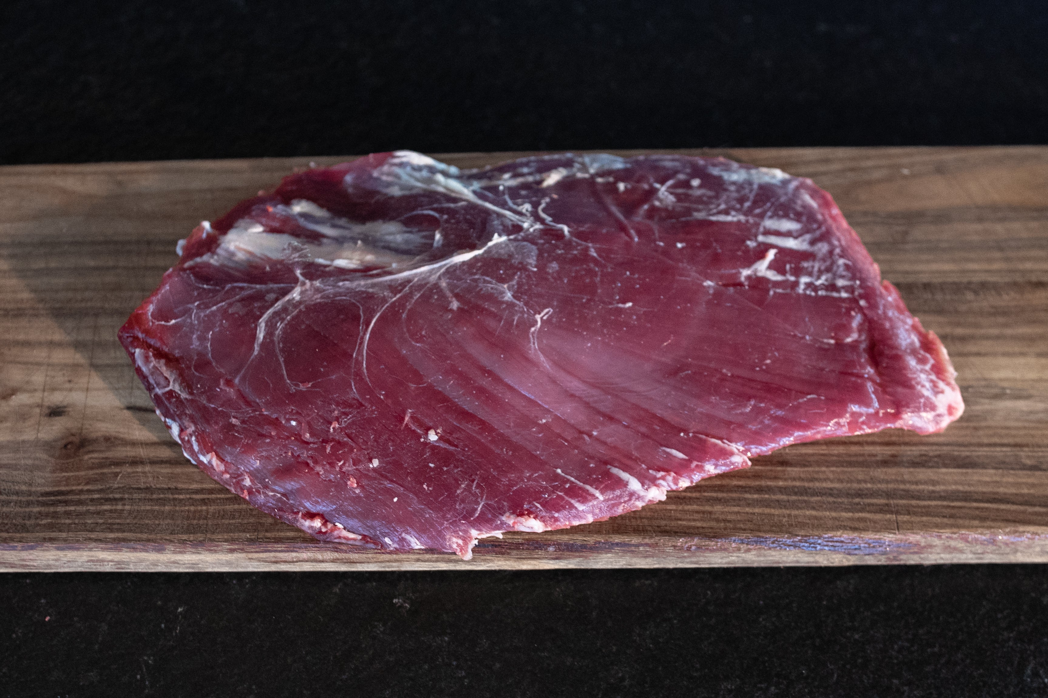 Hovězí flank steak Fox Meadows na dřevěném prkénku – připravený na gril, pečení i pomalé vaření