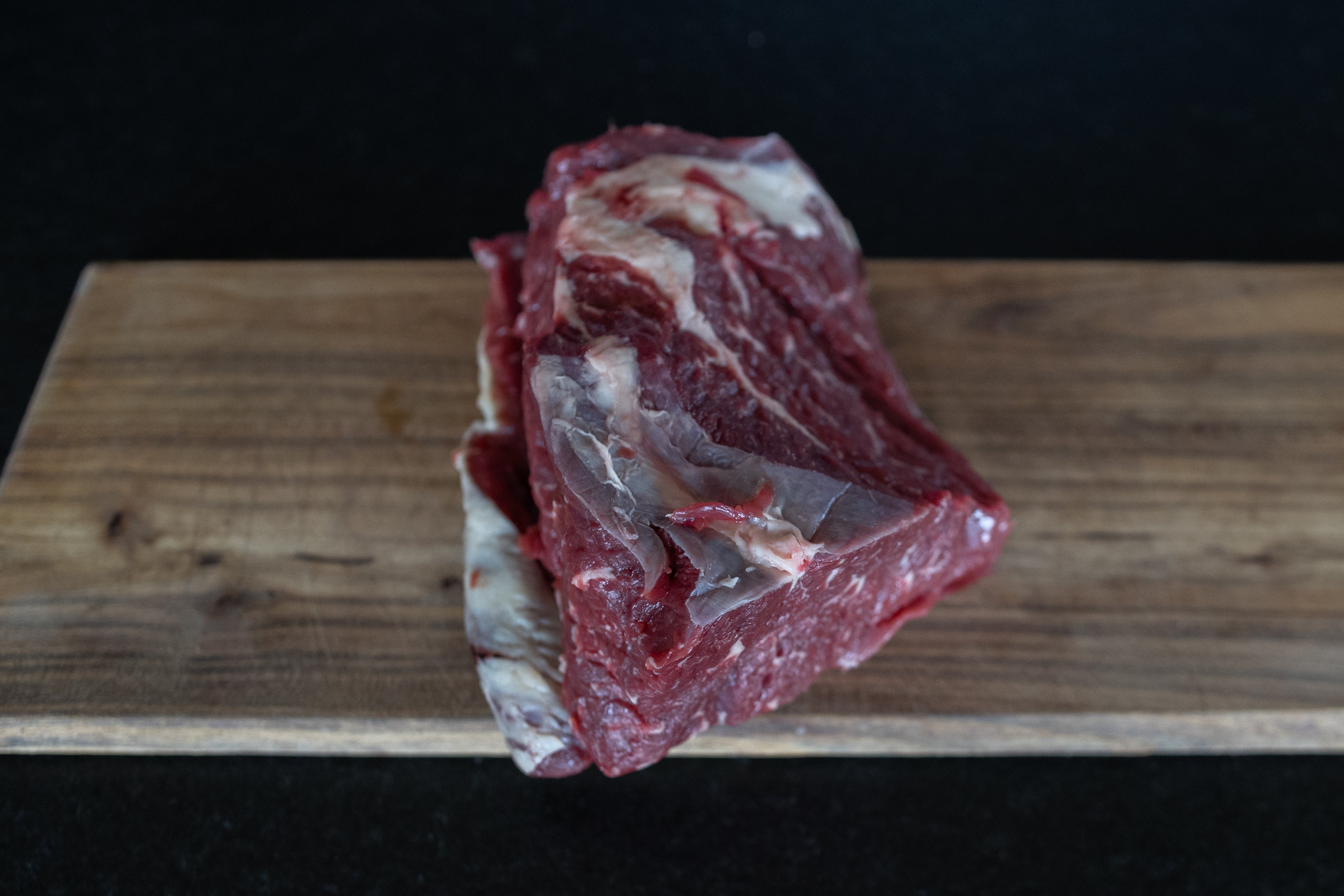 Hovězí krk Fox Meadows na dřevěném prkénku – připravený k pomalému vaření a pečení